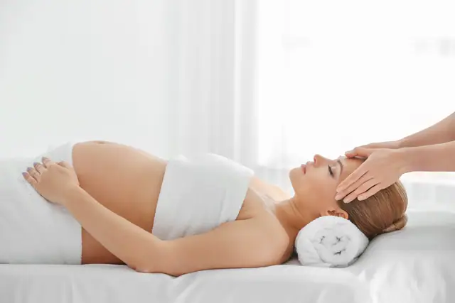 Behandlung in der Schwangerschaft Schwangere Frau erhält eine entspannende Kopfmassage